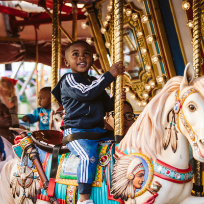 A little boy riding on a carousel at a carnival