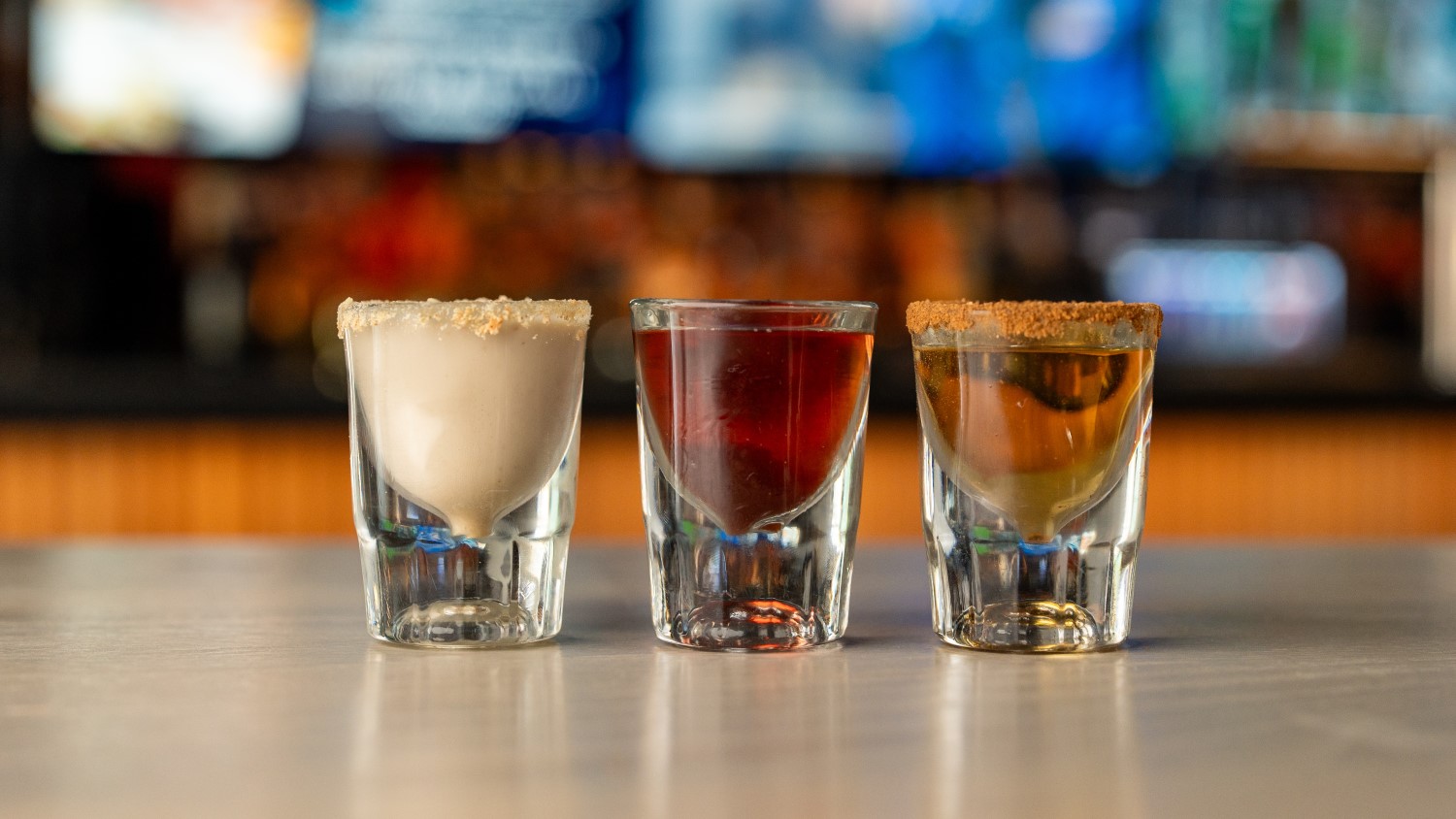 Three shots lined up on a bar.