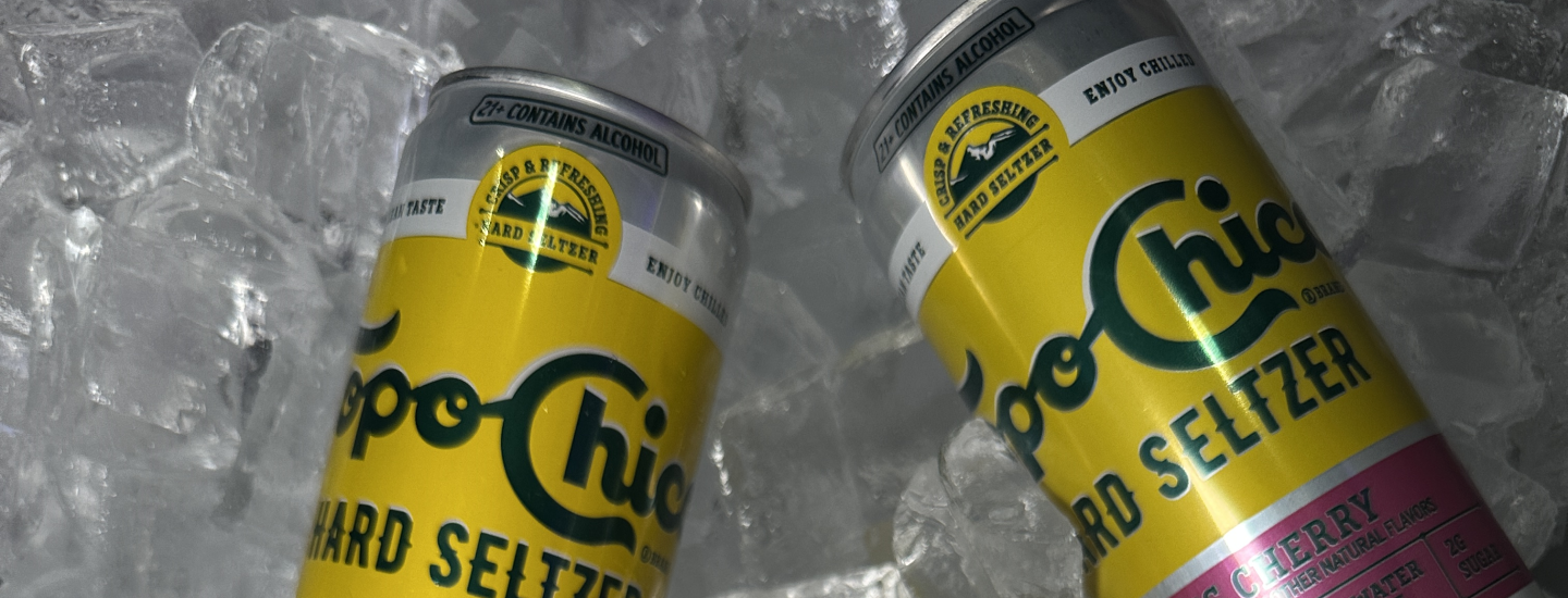 Two Topo Chico Hard Seltzer cans on ice.